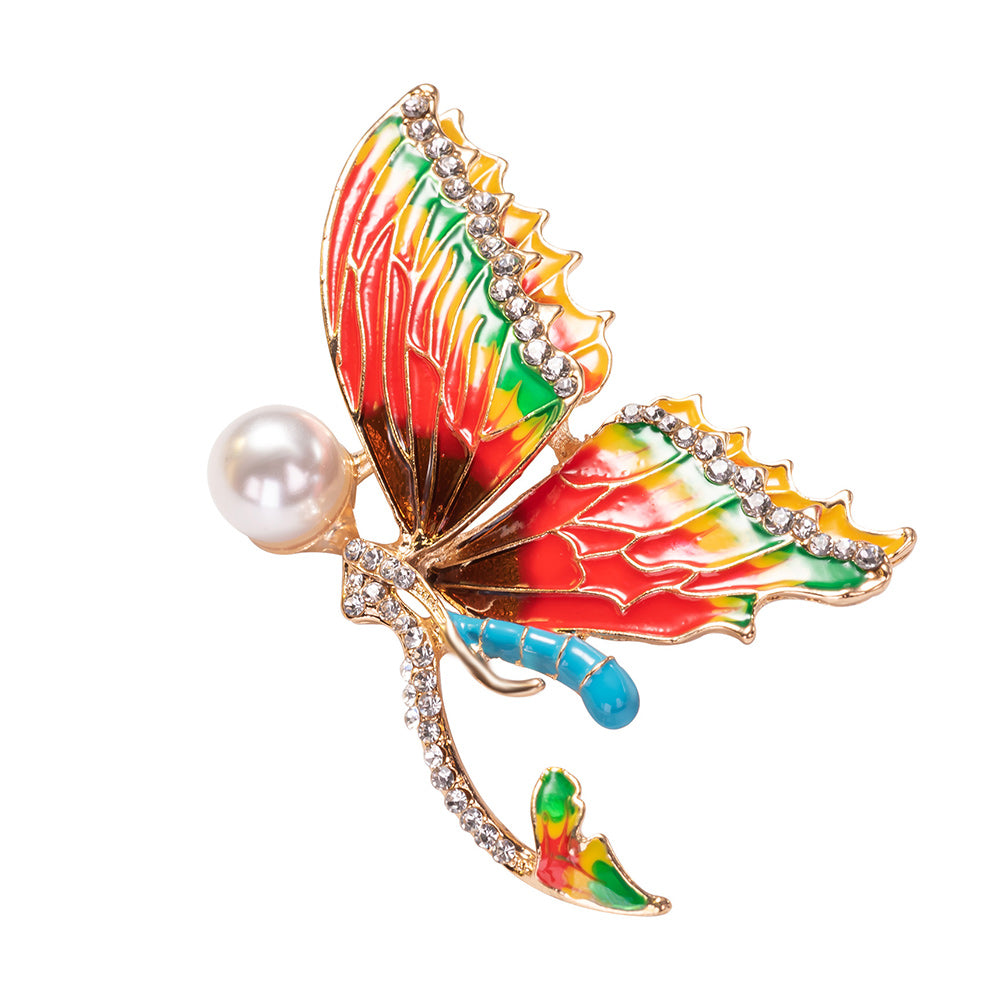 Colorful butterfly-shaped brooch with a pearl on a white background