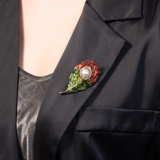 A vibrant peacock feather brooch styled as a statement accessory on a dark navy velvet blazer