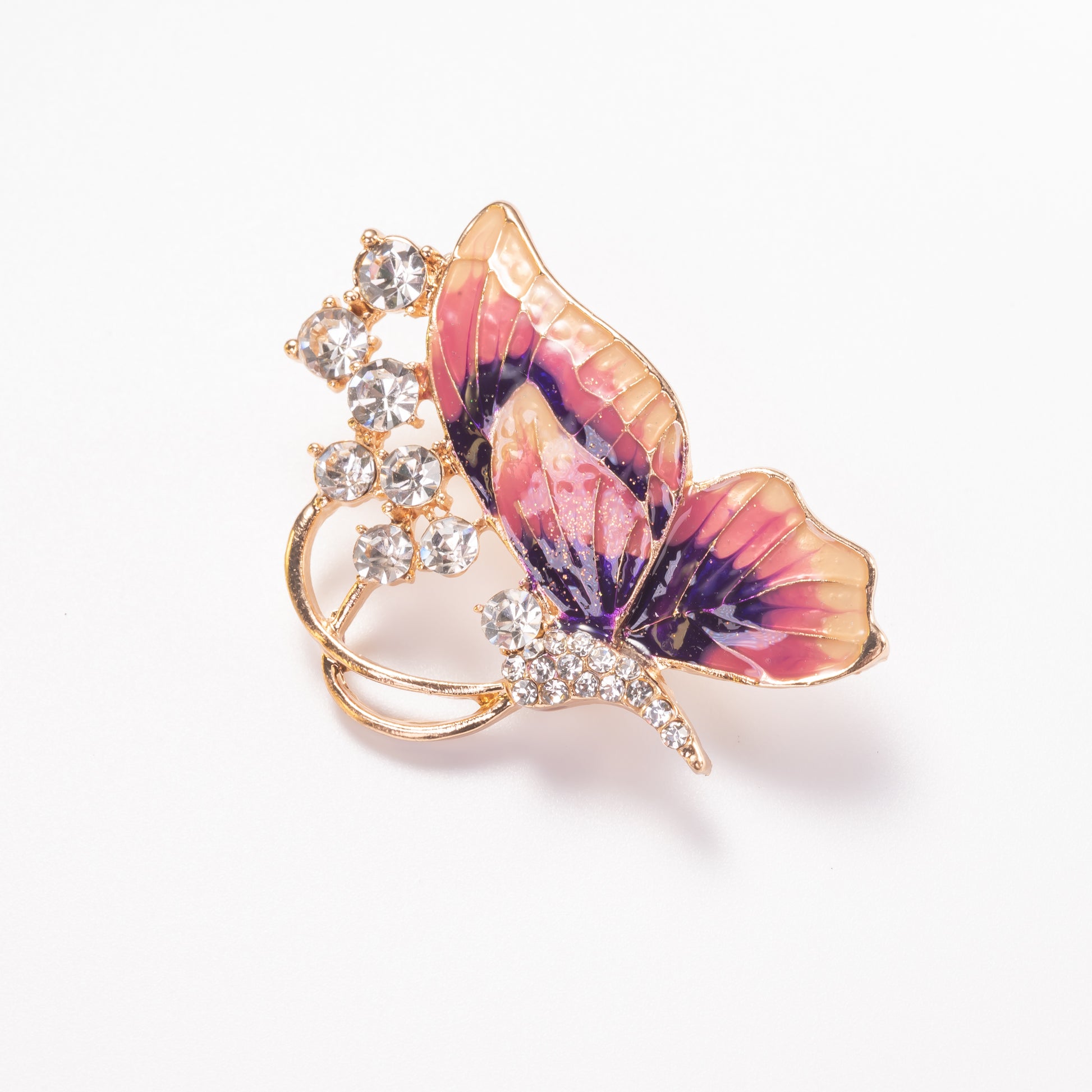 Butterfly-shaped brooch with pink and purple wings and gold accents on a white background
