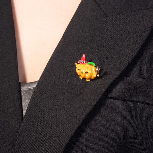 the glossy enamel finish and cheerful face of the Halloween jack-o'-lantern brooch