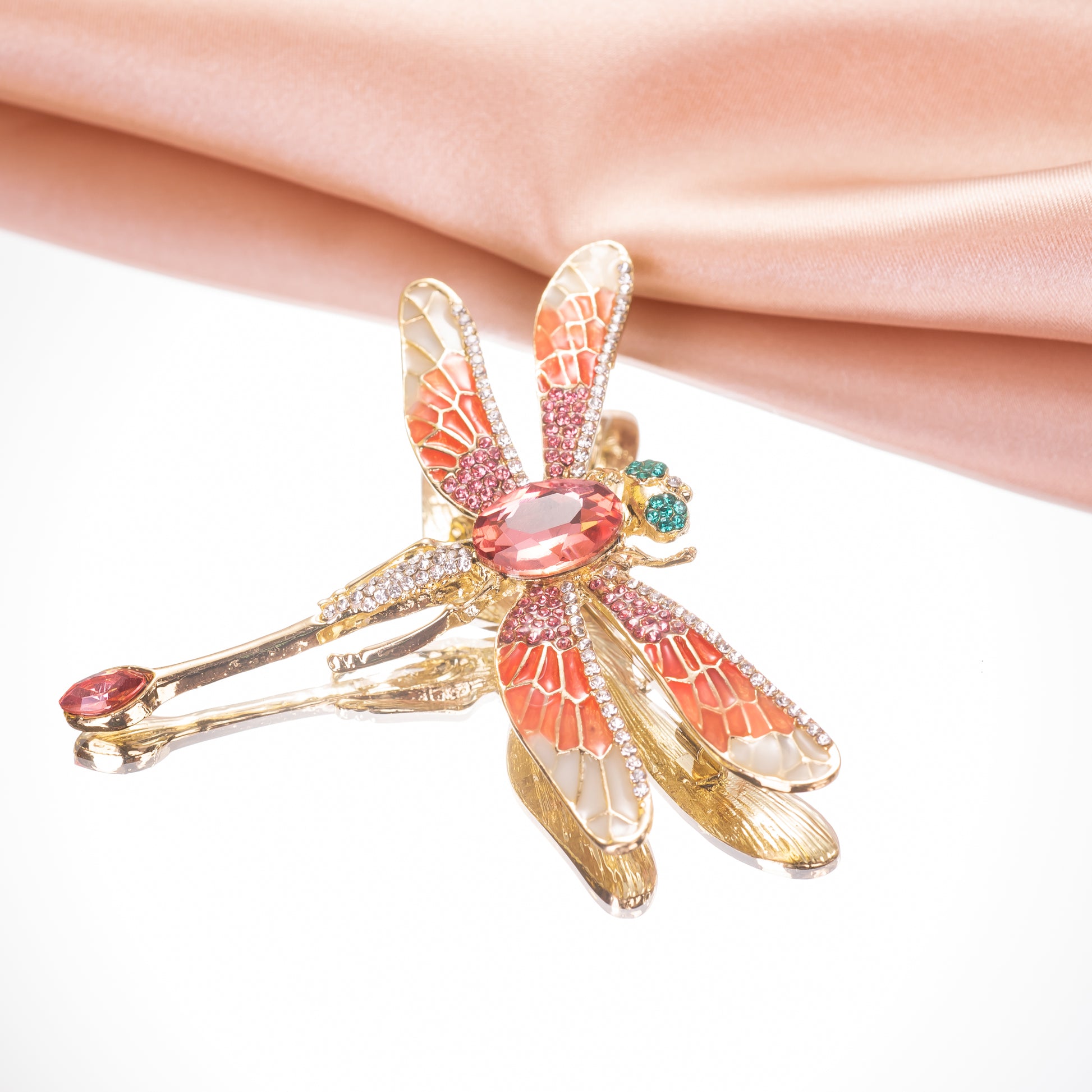 the shimmering crystal accents and detailed enamel wings on the dragonfly pendant